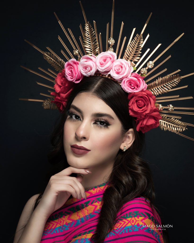 Cómo prepararte para una sesión de fotos y disfrutar la experiencia Retrato artístico de mujer con flores y tocado dorado.